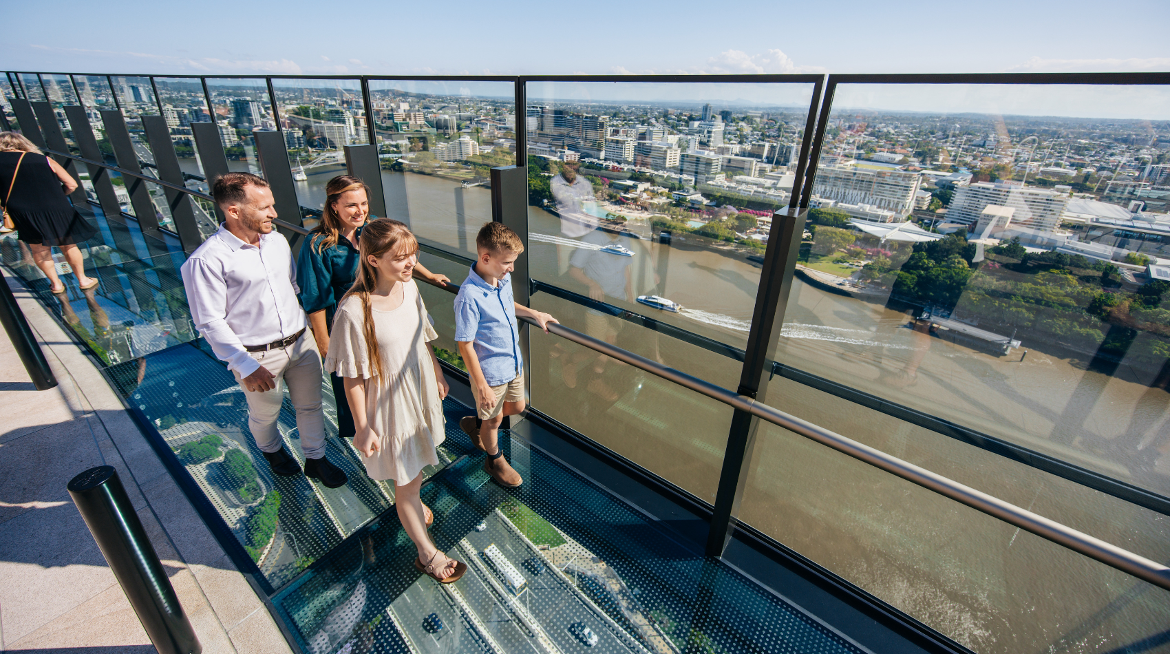A family of four walking along the Sky Deck on a sunny day.